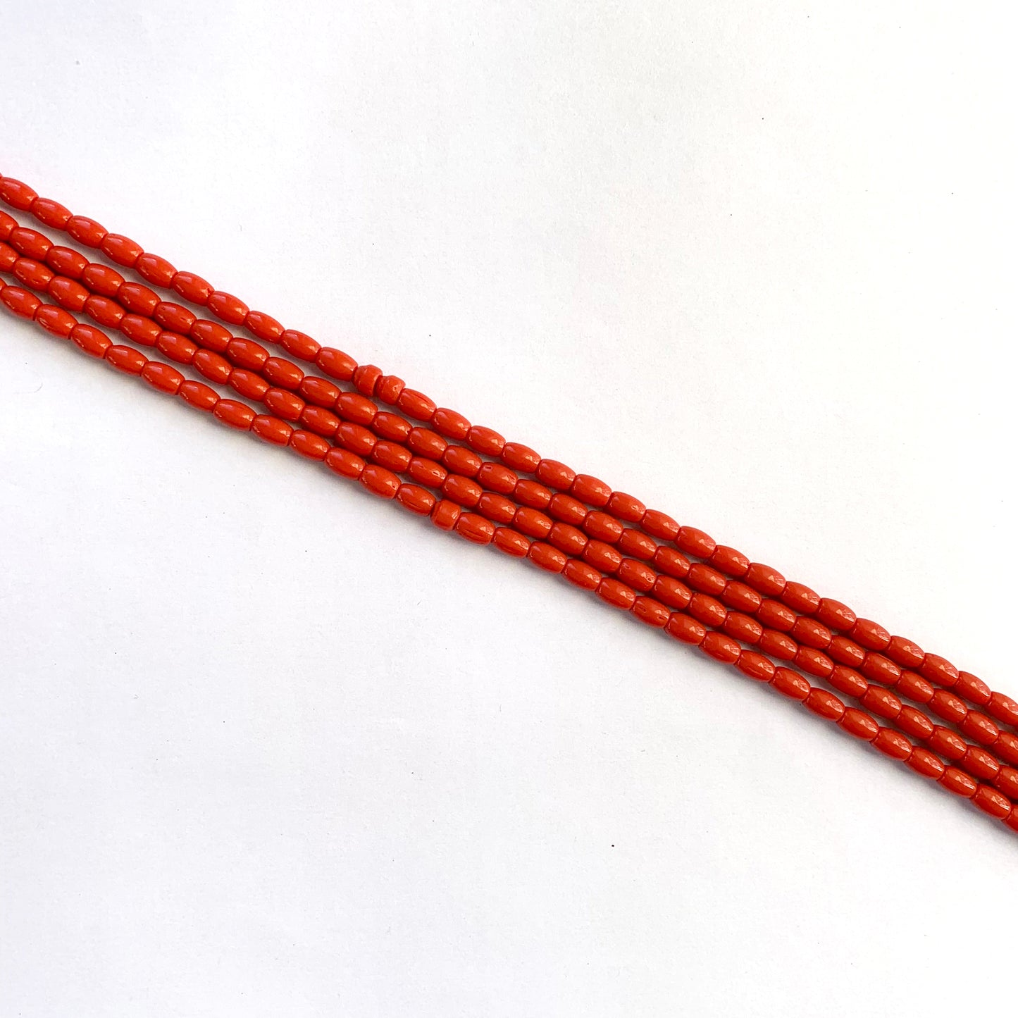 Smooth coral gemstones with natural drum shape ranging from 6.4x4.1mm to 6.7x4.4mm.
