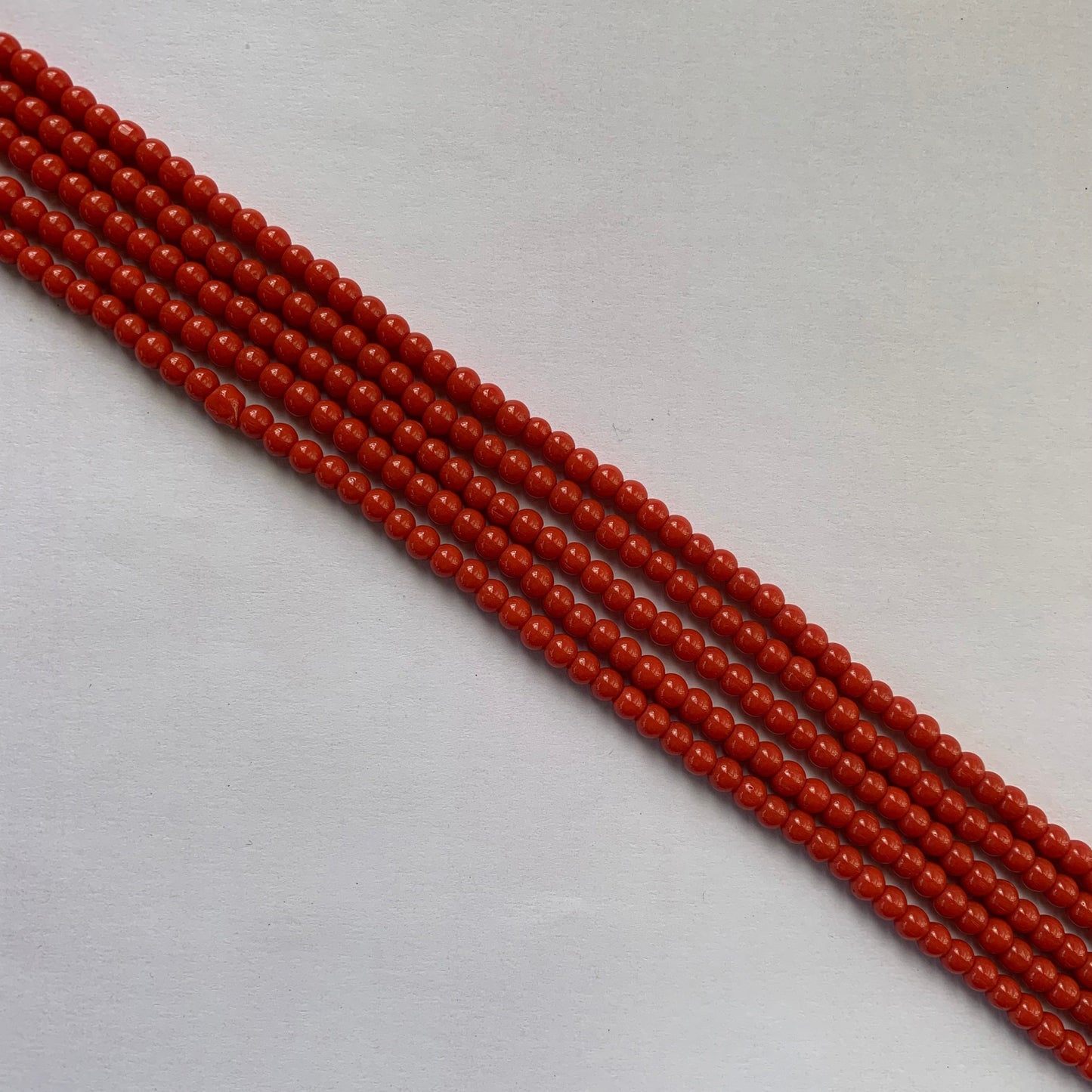 Coral gemstones in a smooth round cut, glowing under natural light.