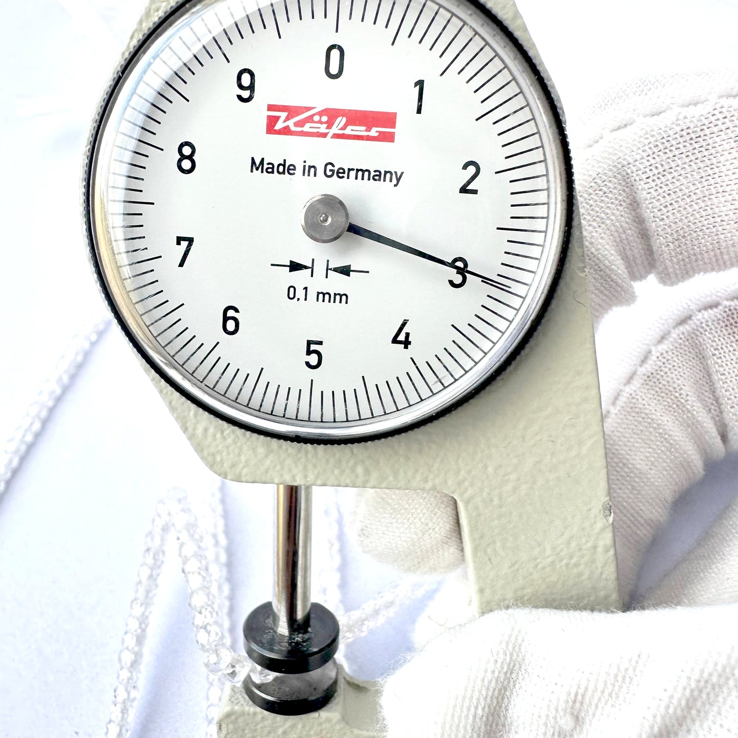 A dial gauge measures the Cubic Zirconia faceted rondelle 3.0mm gemstone.