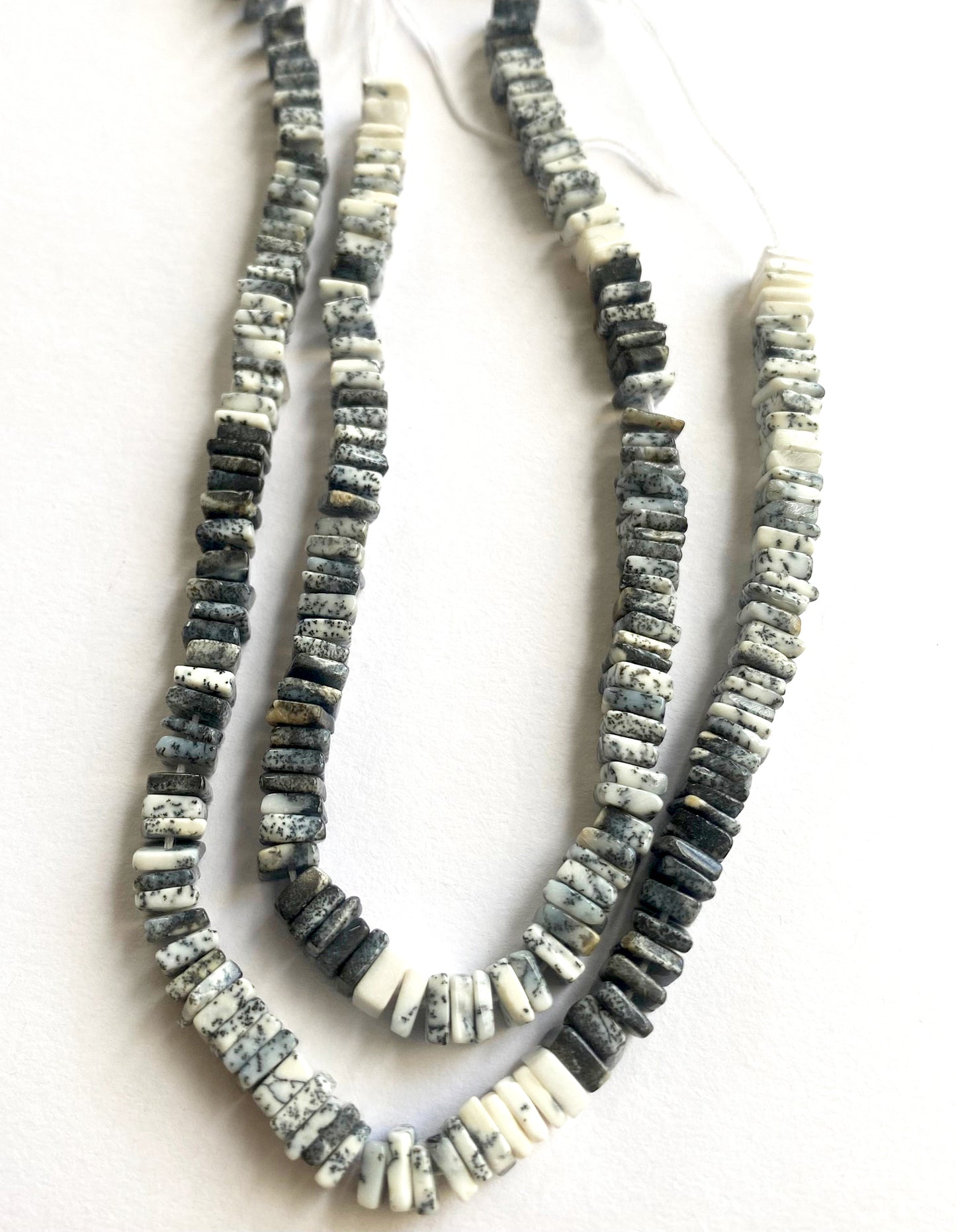Square-cut Dendrite Opals laid flat on a display surface to reveal texture and colour depth.