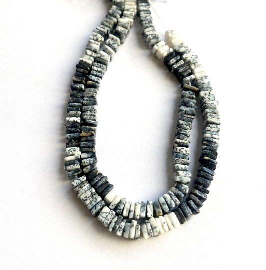 Dendrite Opal beads reflect light softly, highlighting their natural grey and white patterns.