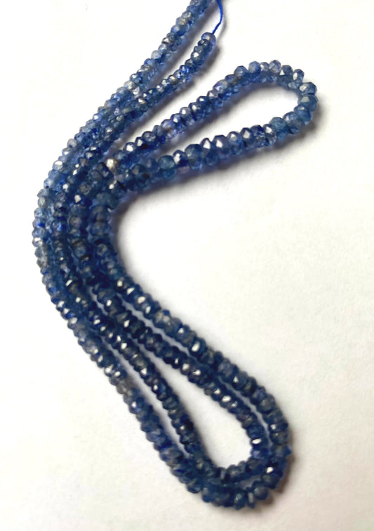 Close-up of 3-4mm Denim Blue Sapphire beads with crisp faceting and consistent round shaping.