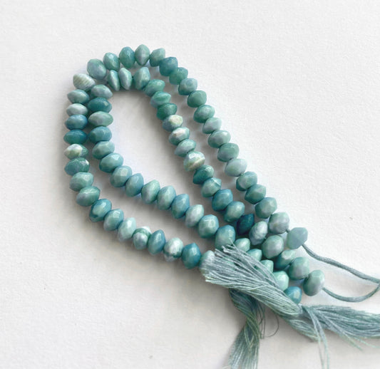 Close-up of denim opal gemstone beads showing their faceted rondelle cut and natural shimmer.