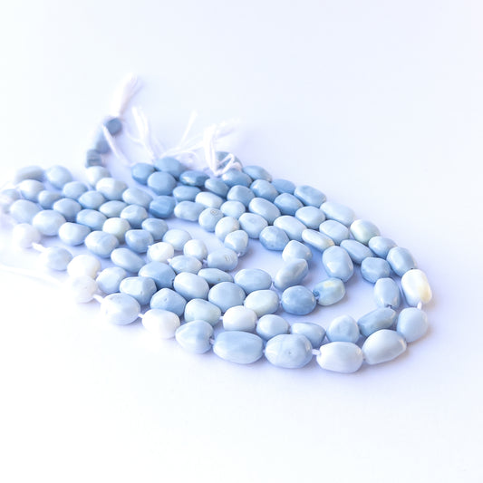 Genuine stone beads in soft denim‑blue hues, featuring smooth tumbles for DIY jewellery making.