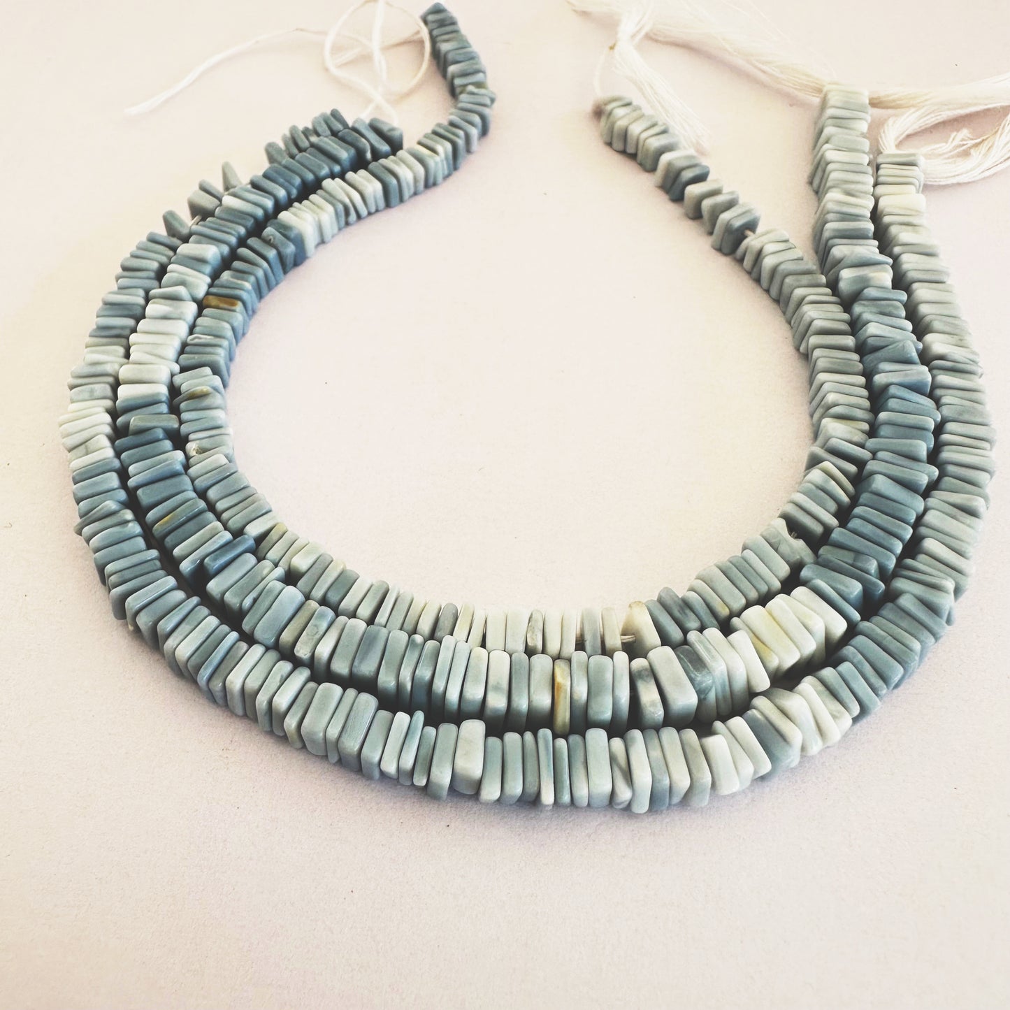 Denim Opal beads styled into a bracelet, highlighting cut precision and colour gradient.