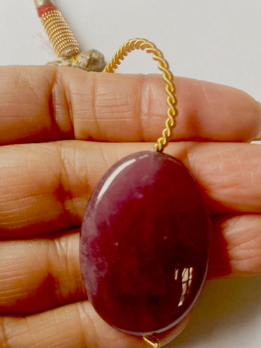 Close-up of Ruby pendant showing glossy finish and vibrant colour across 90 carats of gemstone weight.