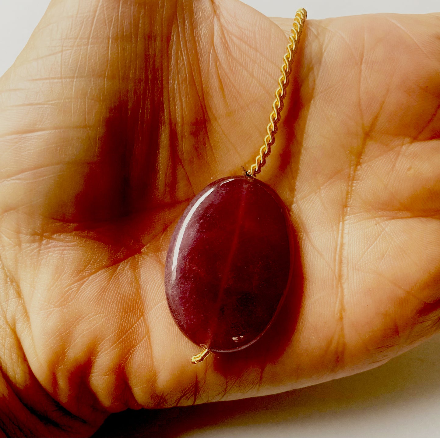 Ruby pendant positioned to showcase depth, clarity, and consistent cut with drilled hole detail.