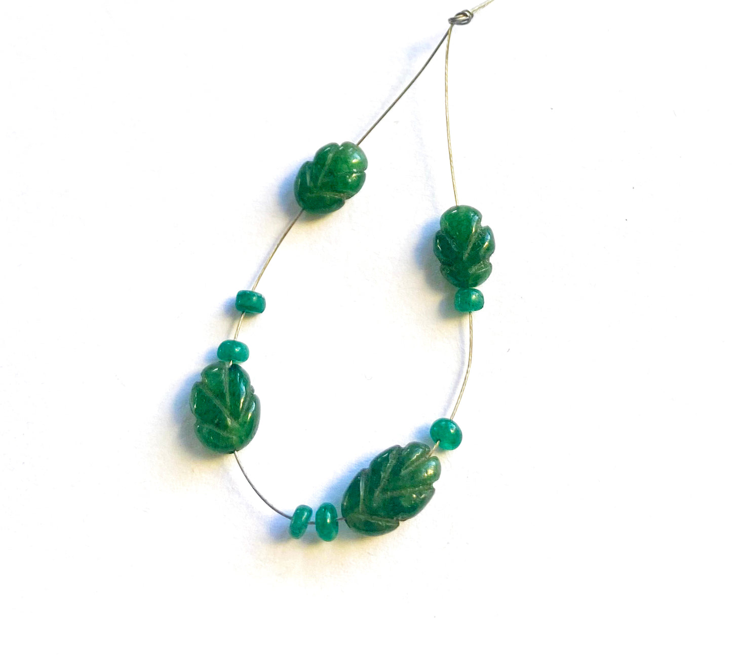 Emerald carved beads display deep green tones and elegant hand-cut details.