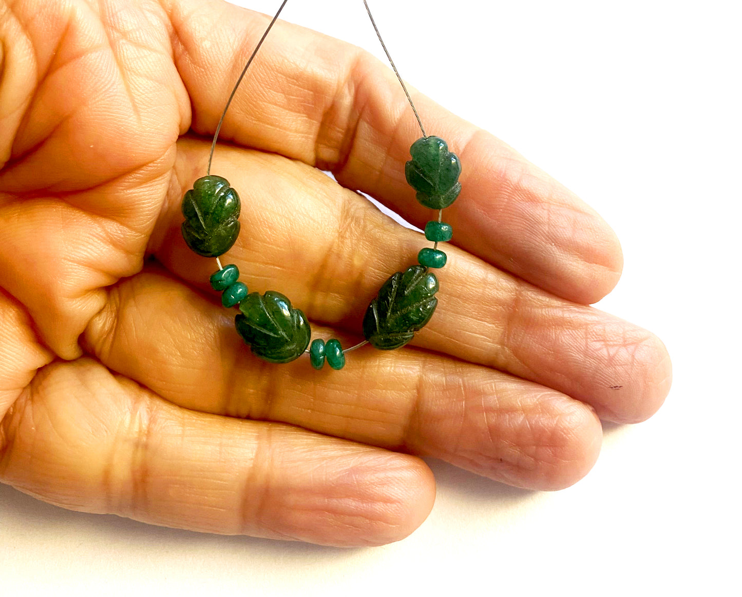 Bright emerald beads with finely carved edges and smooth polished rondelles.
