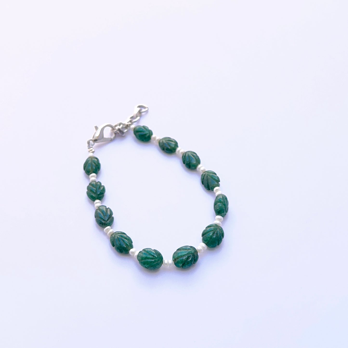 Elegant bracelet with carved emerald beads paired with smooth freshwater pearls.