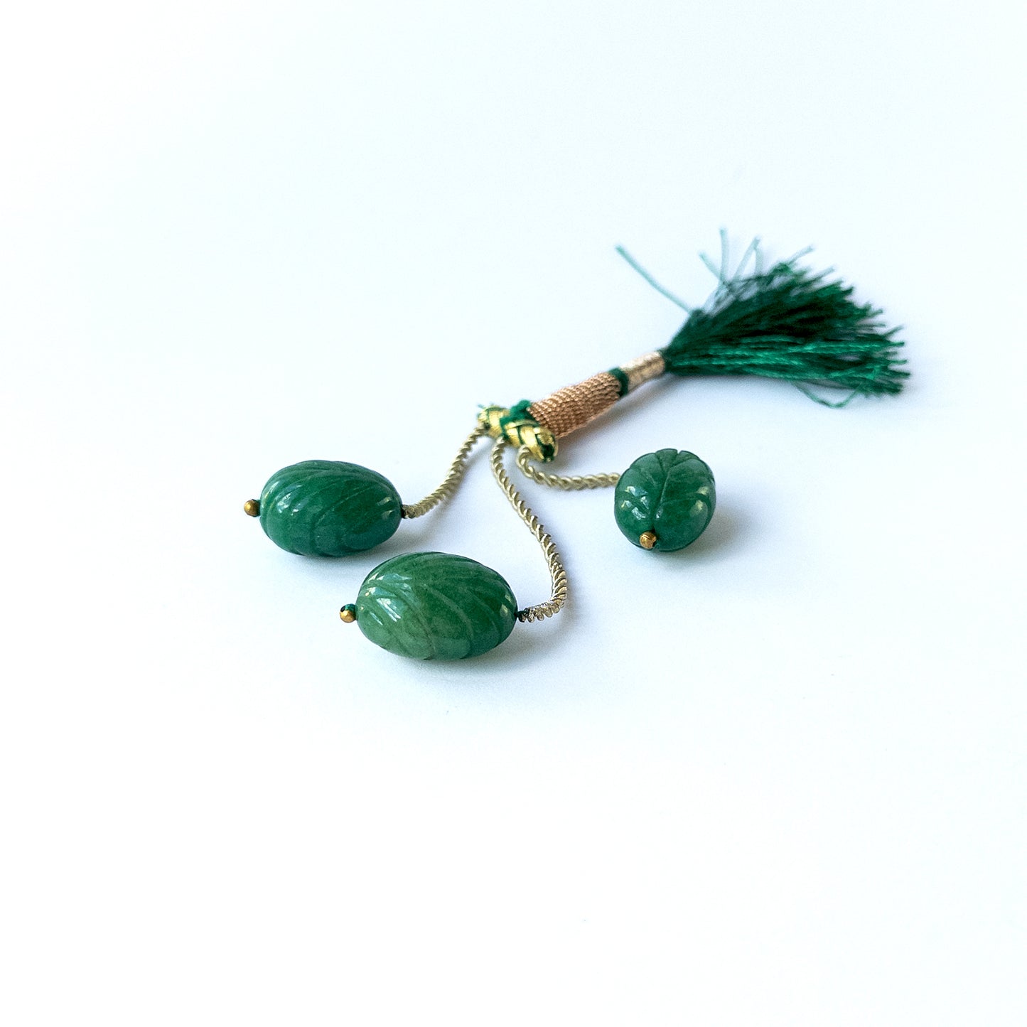 Authentic emerald gemstone beads showcasing rich green tones and intricate carved detailing.