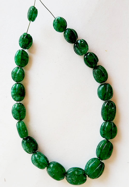 Close-up of emerald carved ovals showing polished texture, fine craftsmanship, and natural depth.