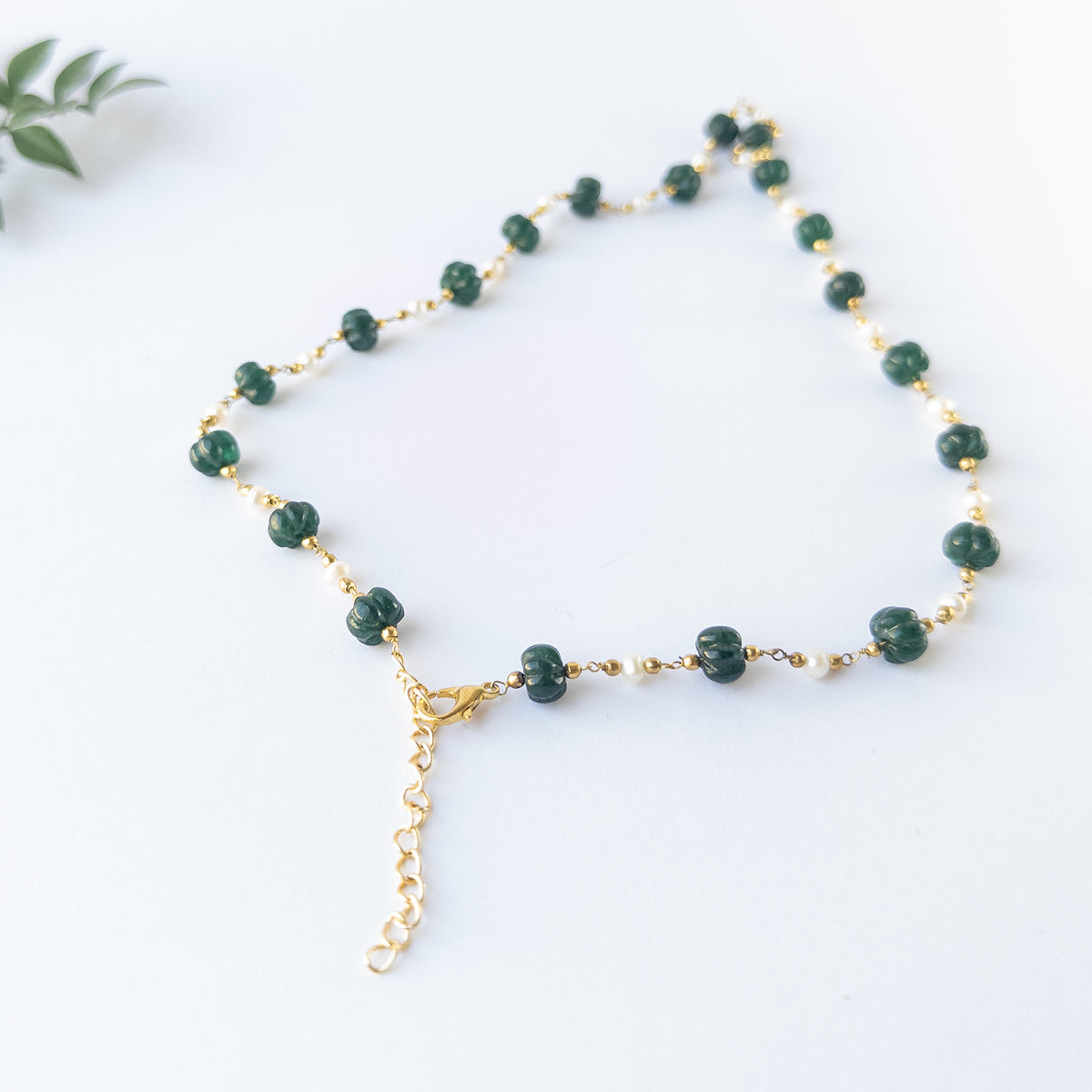Genuine gemstone beads in Emerald and Pearls showing carved shine and quality craftsmanship in a necklace design.