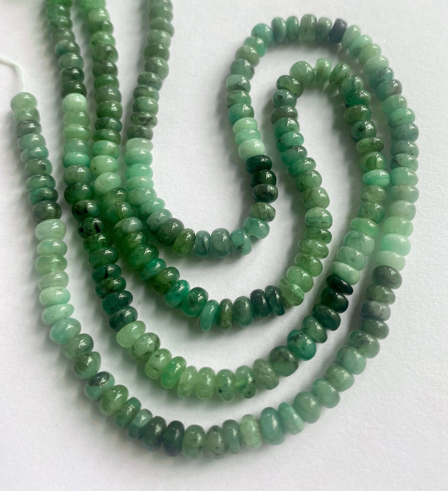 Strand of emerald beads with 5–5.3mm size, highlighting their smooth finish and vibrant colour.