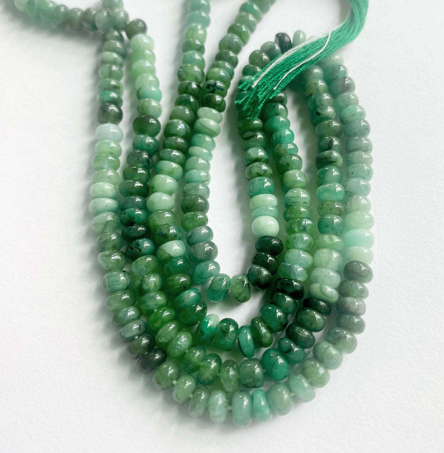 A dial gauge measures the emerald smooth rondelle 5–5.3mm gemstone.