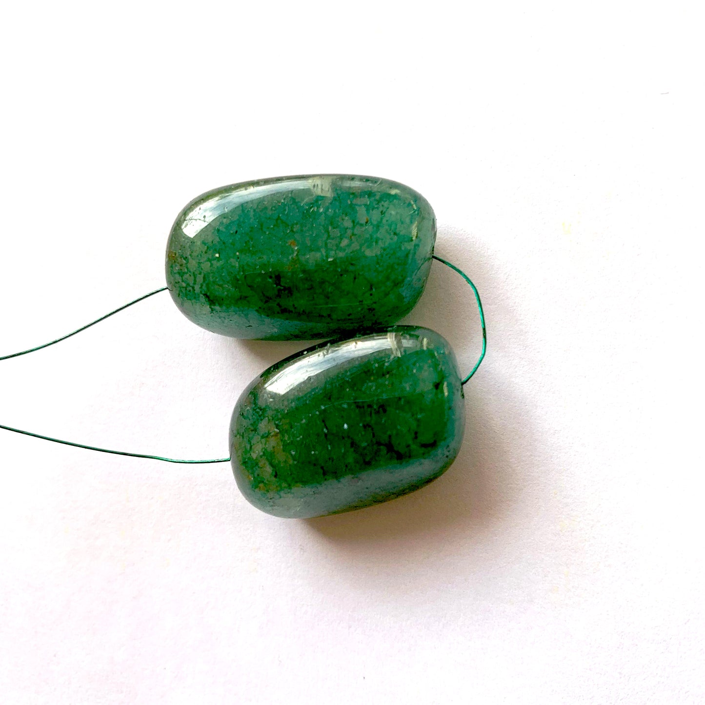 Close-up view of large emerald beads showcasing smooth contours and polished surfaces.