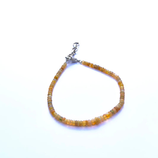 Close-up of luminous Ethiopian opal stone beads arranged in a delicate bracelet.