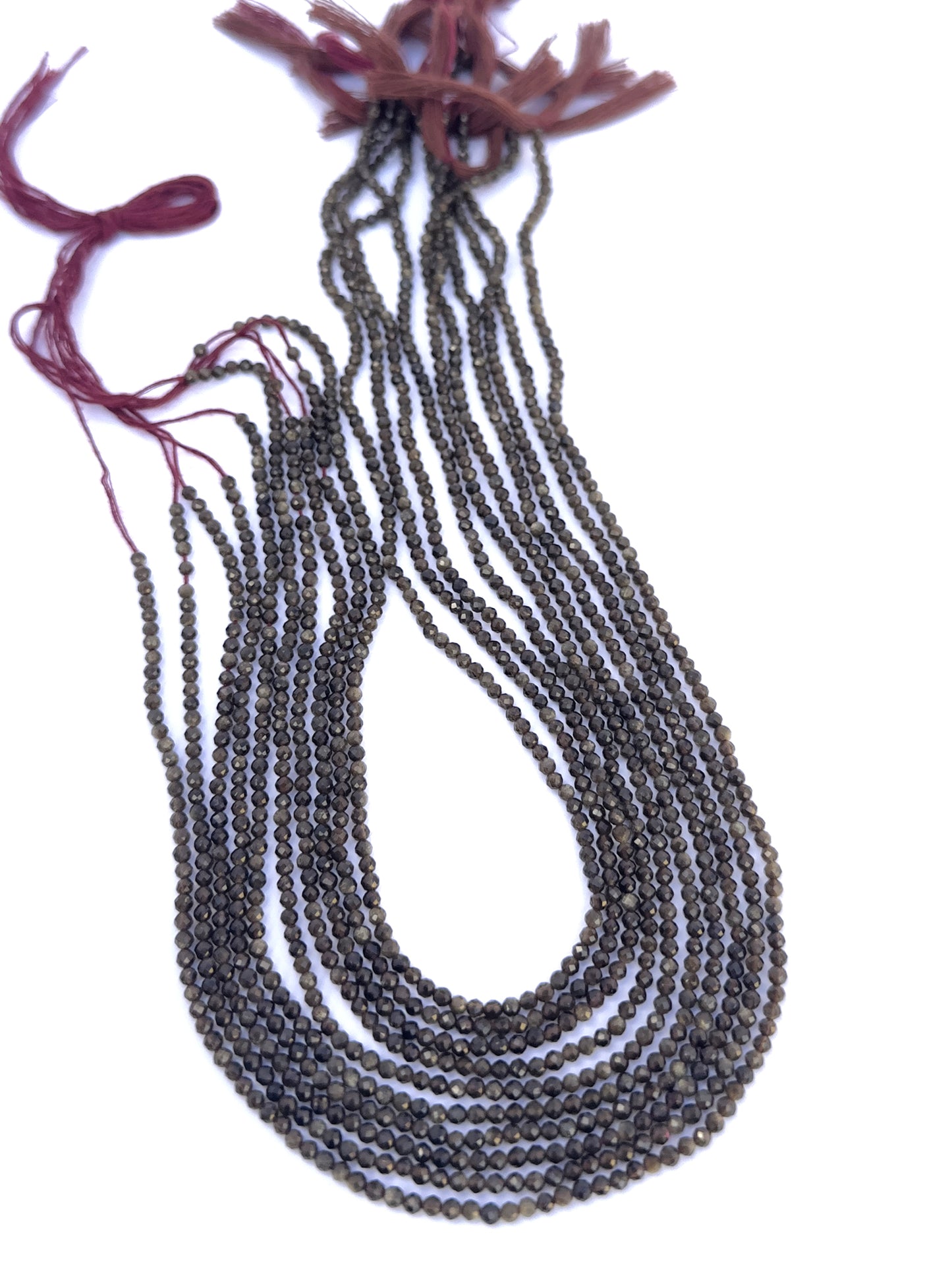 Cat’s Eye gemstone beads laid flat to highlight their faceted surface and uniform size.