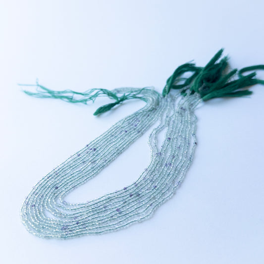 Strand of fluorite faceted rondelles displaying mixed green and purple hues for gemstone beads for DIY jewellery.