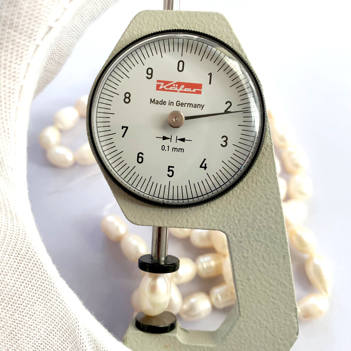 A dial gauge measures the Freshwater Pearl Baroque cut 10 x 7.7mm to 12.5 x 8.0mm gemstone.
