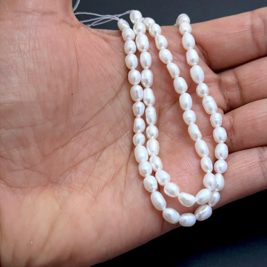 Close‑up of 4.5mm freshwater pearl beads showing smooth surfaces and natural shine ideal for natural gemstone beads for DIY jewellery.
