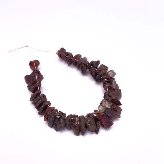 Garnet gemstone beads for jewellery making displayed with soft lighting.