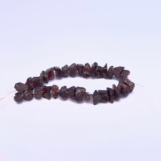 Garnet gemstone beads for handmade jewellery displayed with soft lighting.