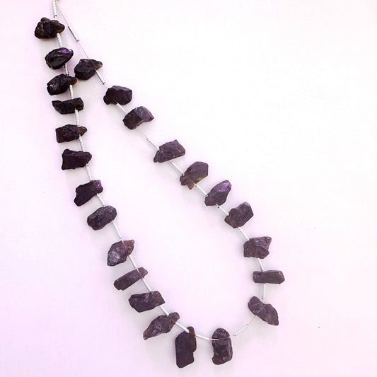 Close-up of Garnet side-drilled rough gemstones showing raw finish and rich colour variation.