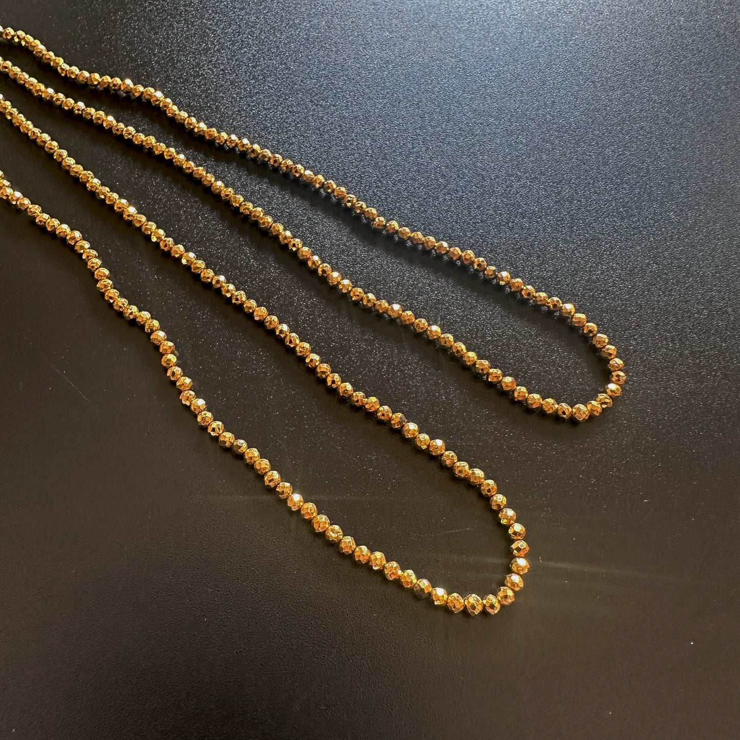 Detailed view of gold pyrite rondelle beads with shimmering golden tones and clarity.