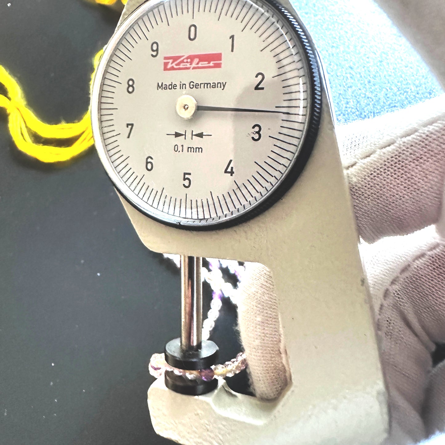 A dial gauge measures the Golden Rutile faceted rondelle 2.6mm gemstone.