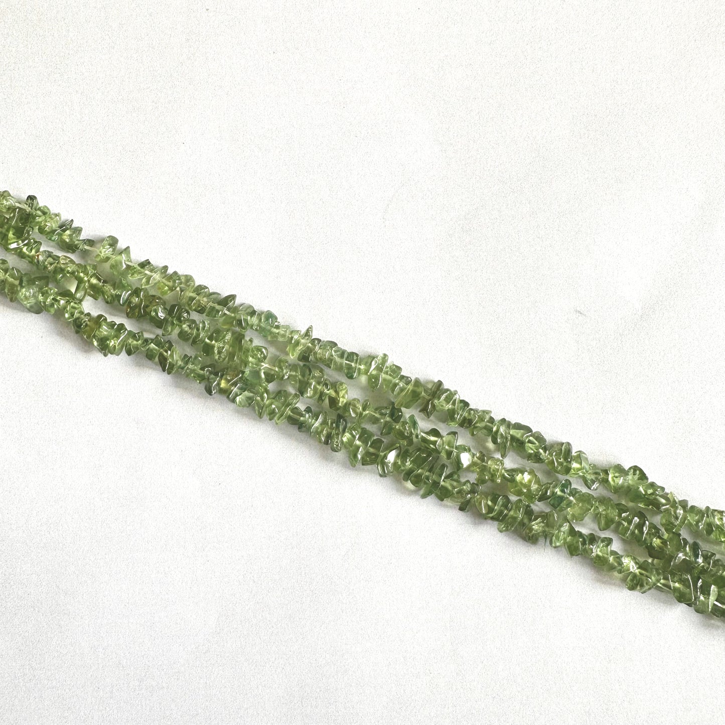 Smooth Green Apatite chip beads with translucent green tones on a 22cm strand.