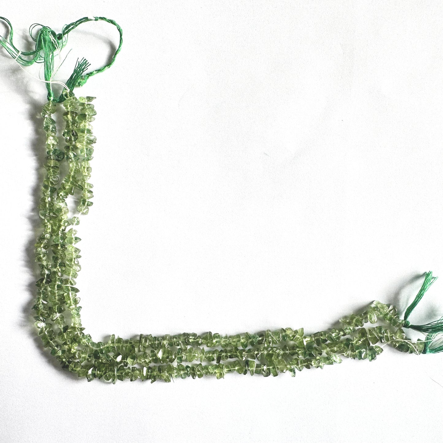 Grouped Green Apatite chip beads with organic shine and varied green saturation.