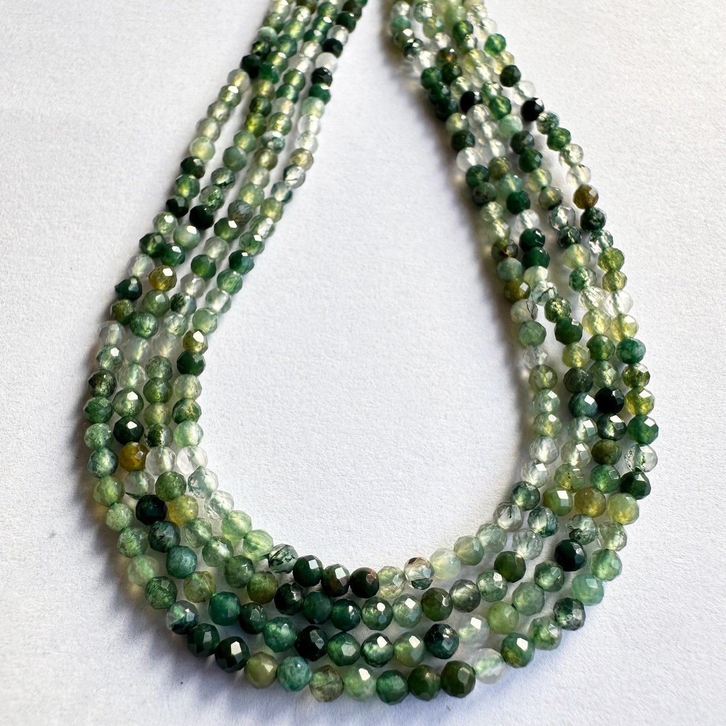 Loose green aventurine faceted rondelles spread out to reveal their clarity and uniformity.