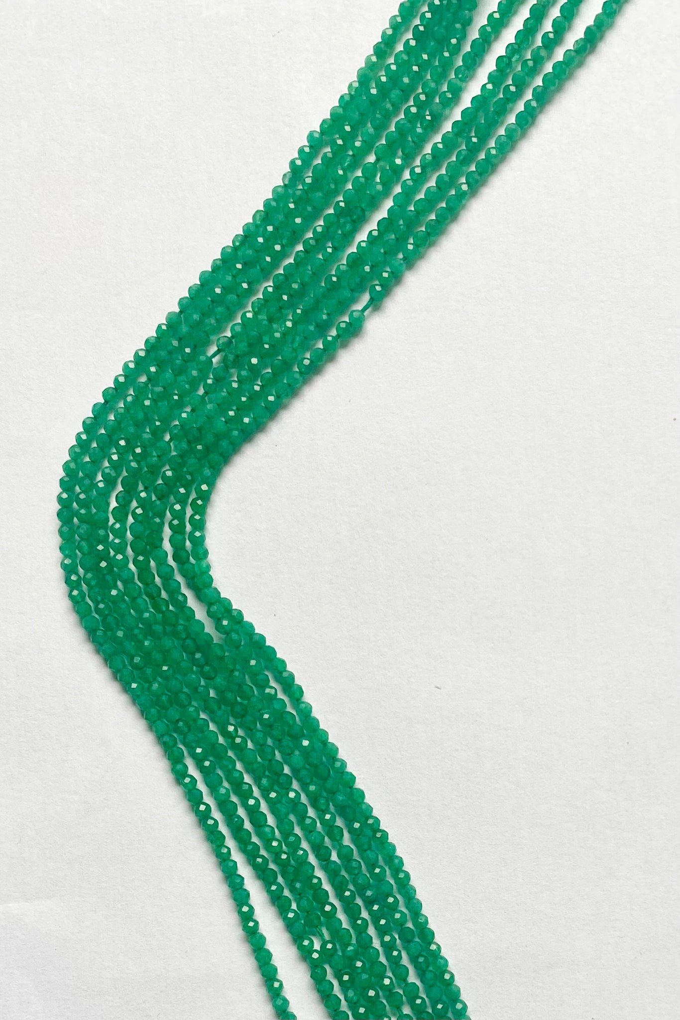 Vibrant Green Onyx micro-faceted rondelle beads, 2.4mm, elegantly arranged on a 32cm strand.