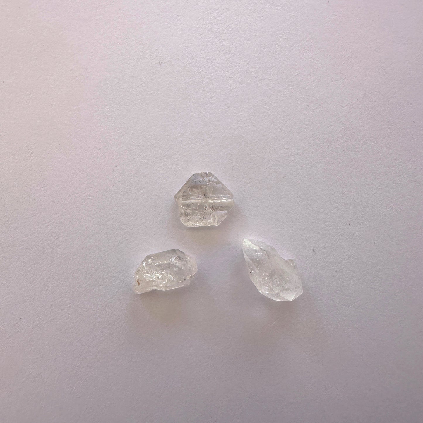 A dial gauge measures the Herkimer Diamond rough cut 9-12mm gemstone.