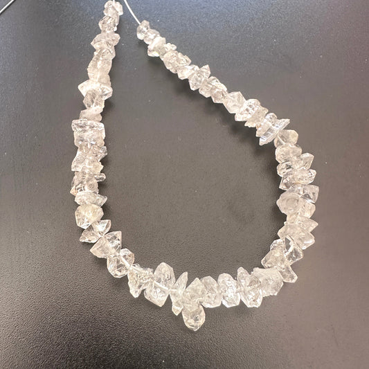 Close-up of Herkimer Diamond crystals showing raw texture and icy brilliance.