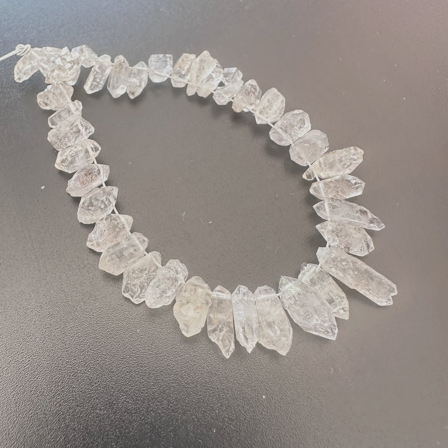 Natural Herkimer diamonds with 0.5mm bead holes displayed on a jewellery mat.