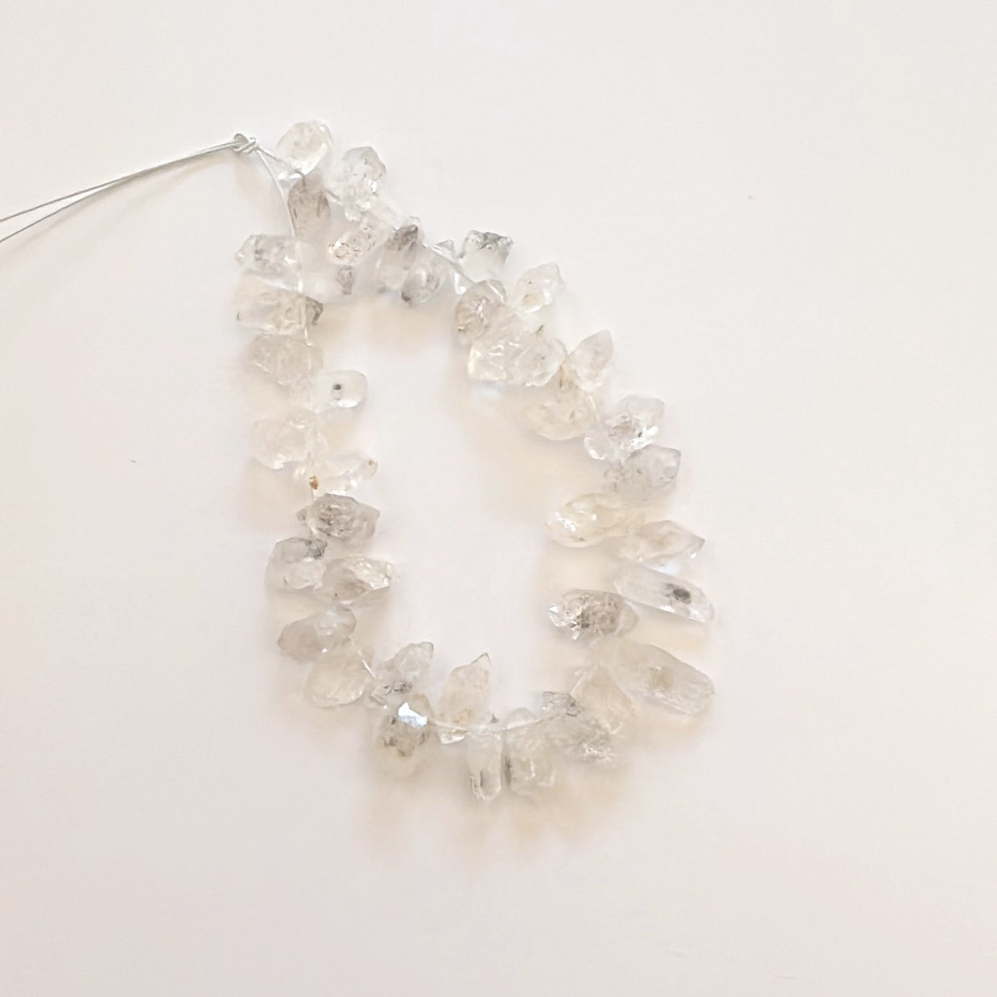 Herkimer diamond beads arranged in a line, highlighting their unique rough texture.