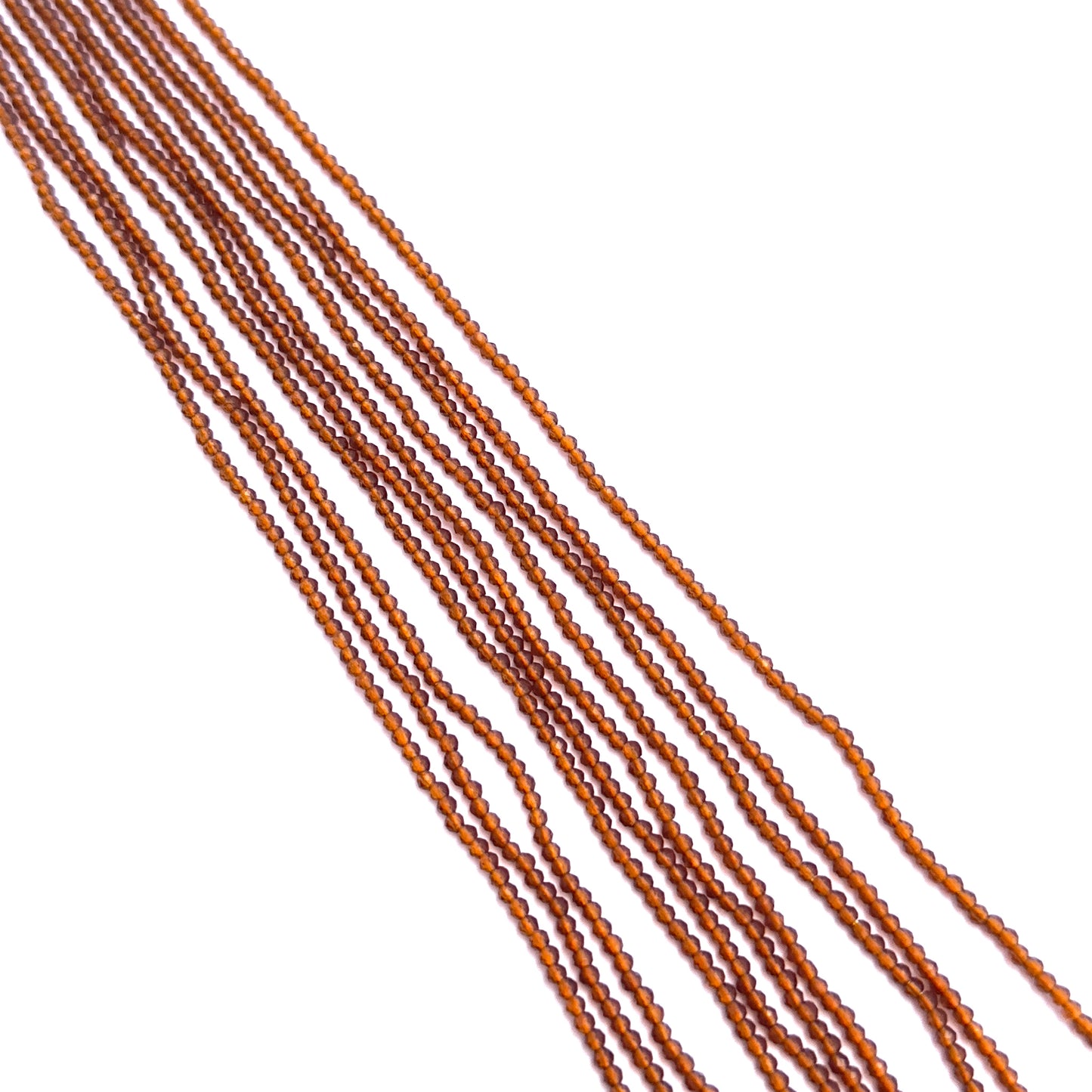 Stone beads in Hessonite finish laid flat to highlight their 2.2mm size and faceting.