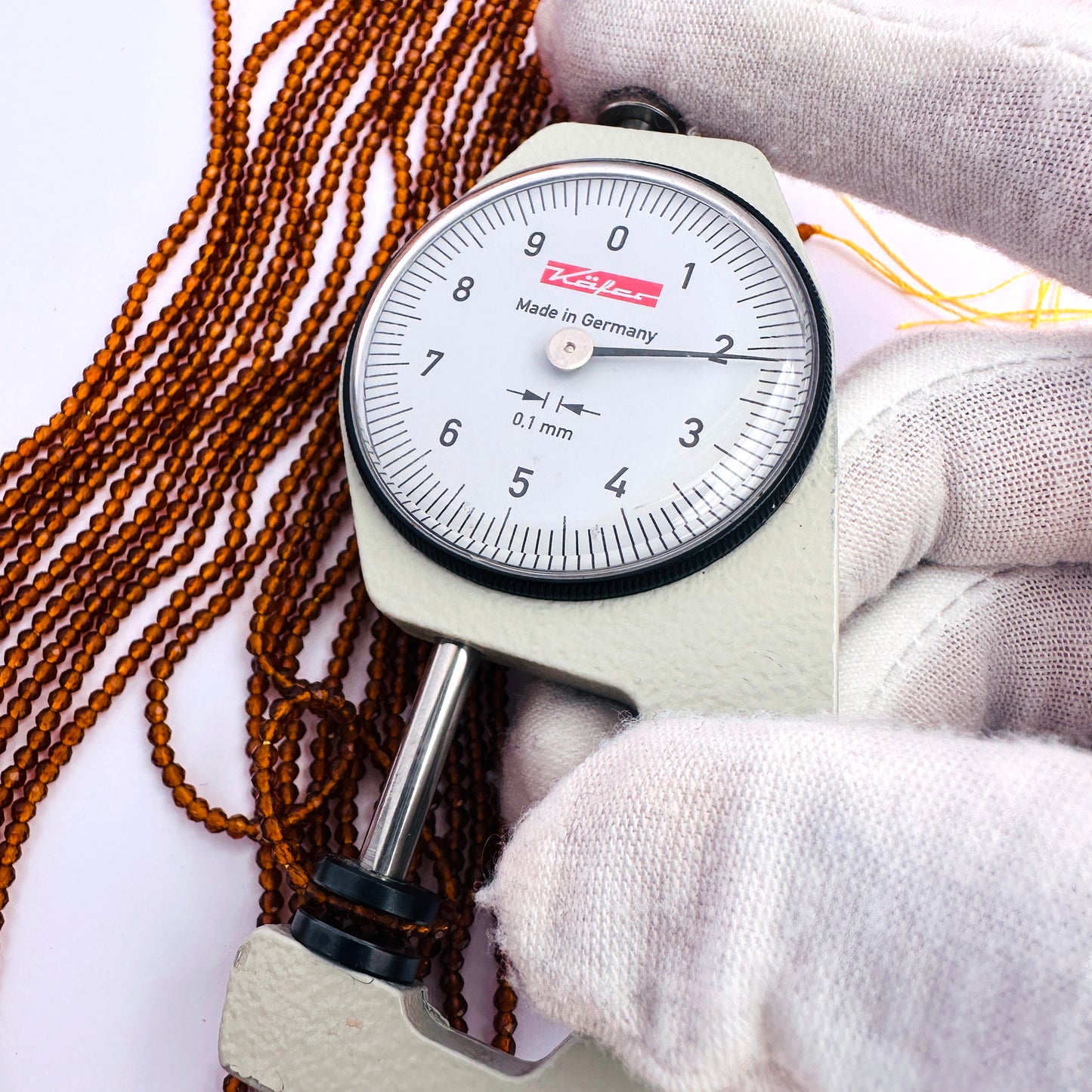 A dial gauge measures the Hessonite faceted rondelle 2.2mm gemstone.