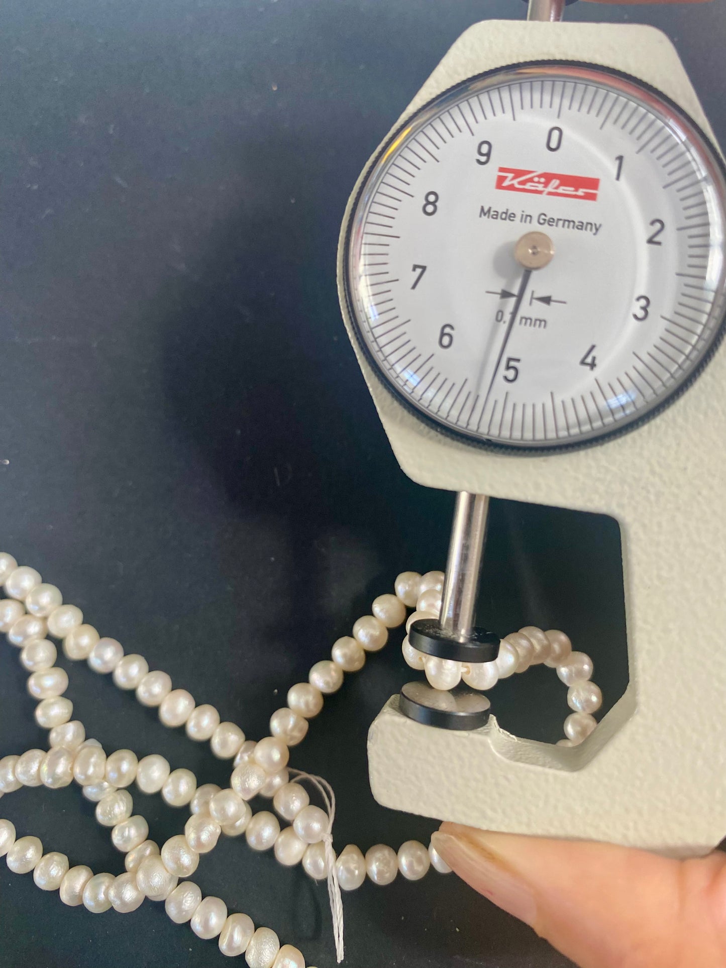 A dial gauge displaying a delicate 5.5-6.0mm freshwater rice pearl strand, highlighting size and measurement.