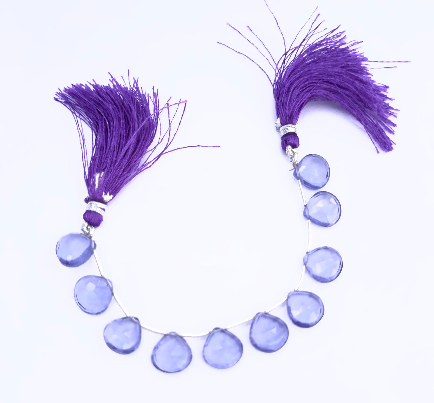 Close-up of Hydro heart briolette beads showing their clarity, cut, and vibrant colour.