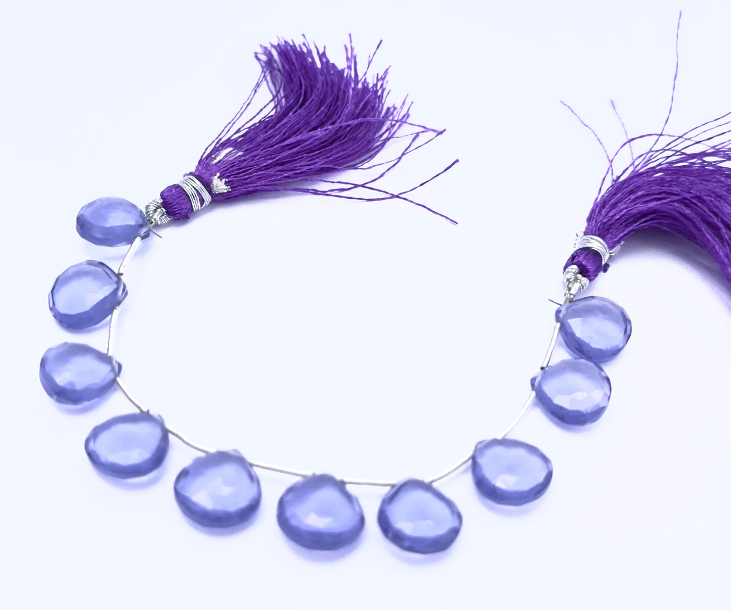 Hydro gemstone beads laid flat to highlight their faceted surface and heart briolette shape.