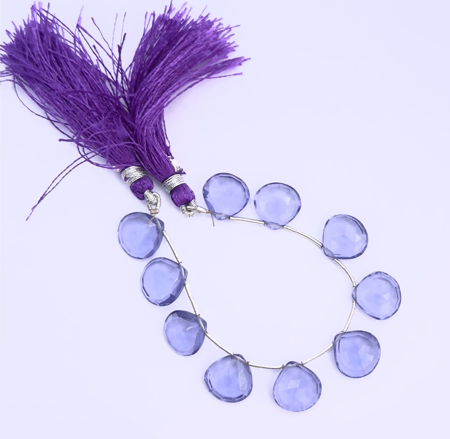 Handmade jewellery components featuring Hydro faceted heart briolette beads in rich purple tones.