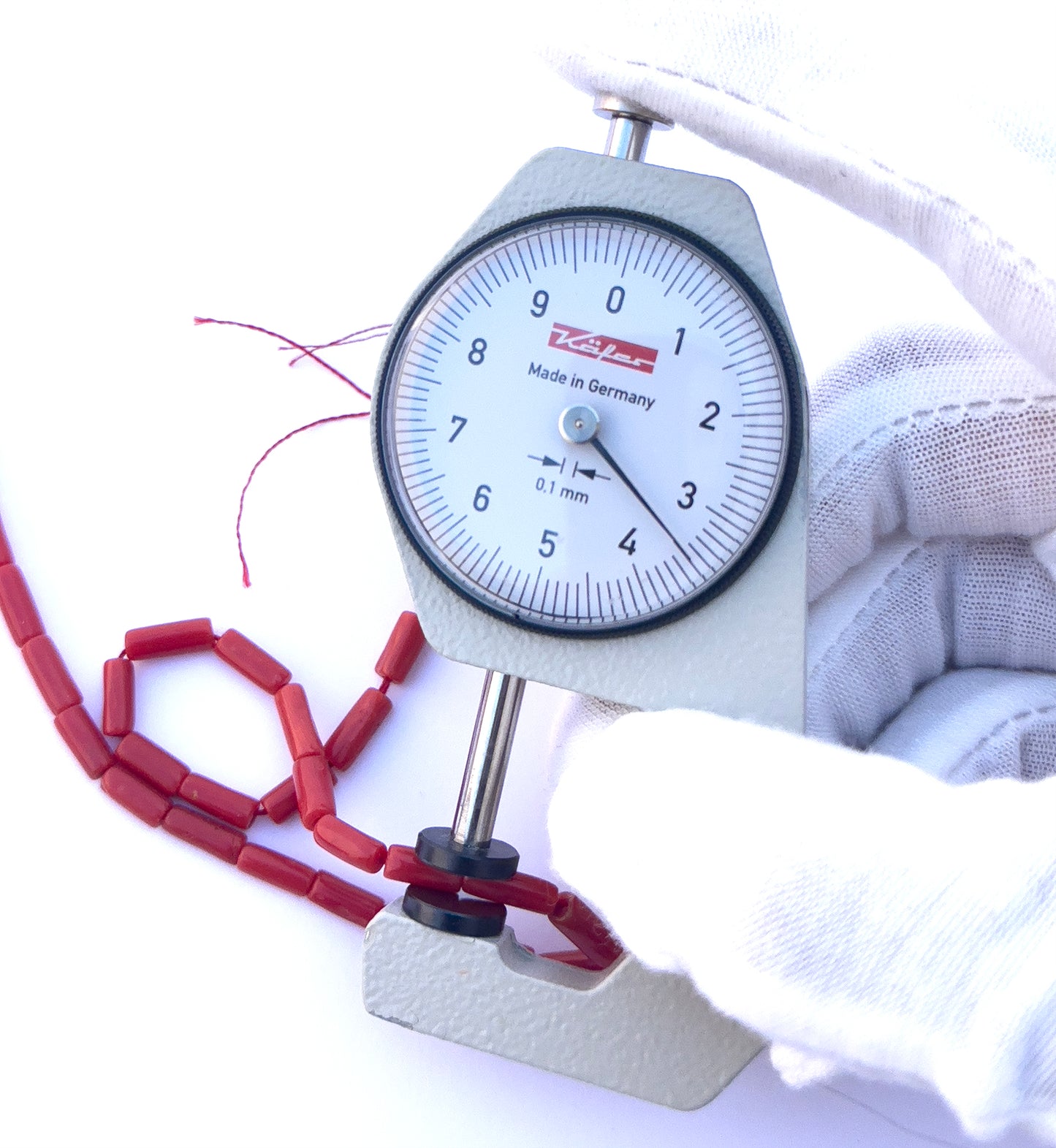 A dial gauge measures the Italian Coral cylinder 3.5mm or 4mm gemstone.