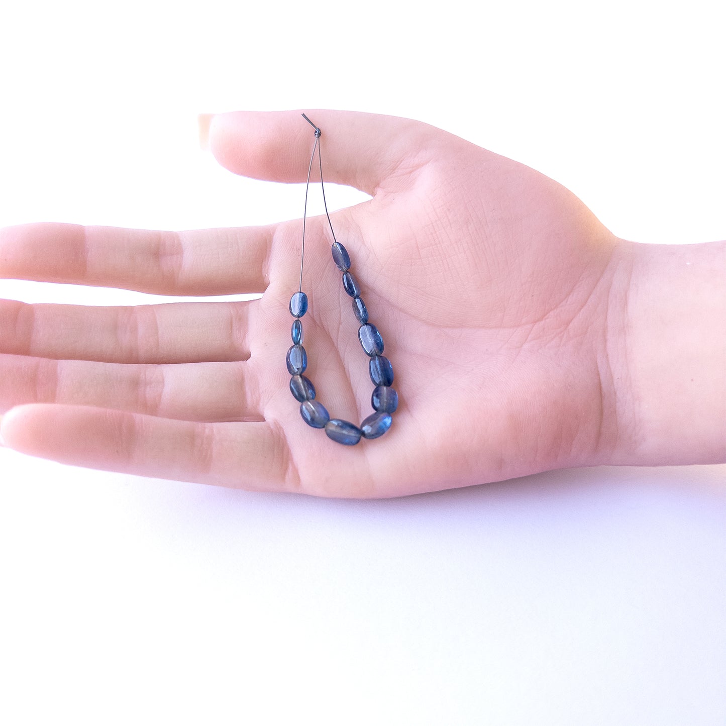 A dial gauge measures the Kyanite smooth oval 4.7–6.2mm gemstone.