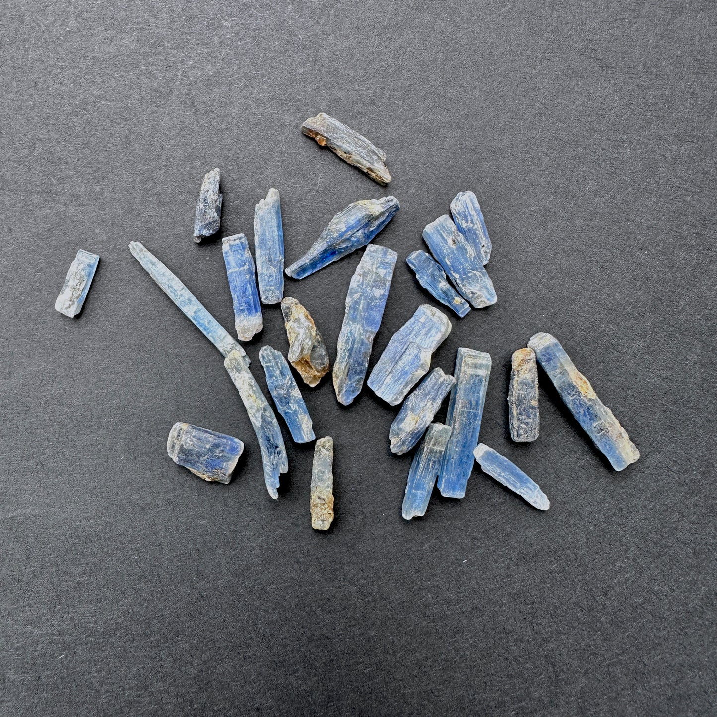 Kyanite gemstones laid flat to highlight their rough cut and elongated shape.