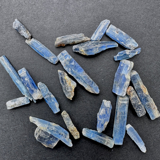 Kyanite rough undrilled stones in natural blue tones arranged together.