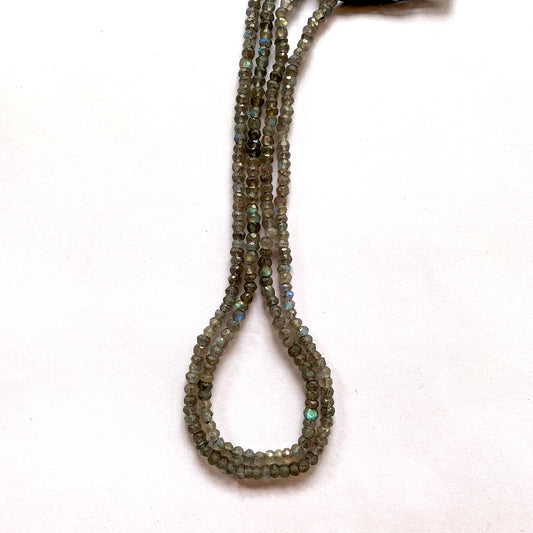 Close-up of Labradorite beads revealing their labradorescence and polished, detailed facets.