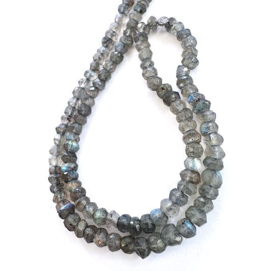 Close-up of Labradorite stone beads showing precision faceted cut and natural labradorescence.